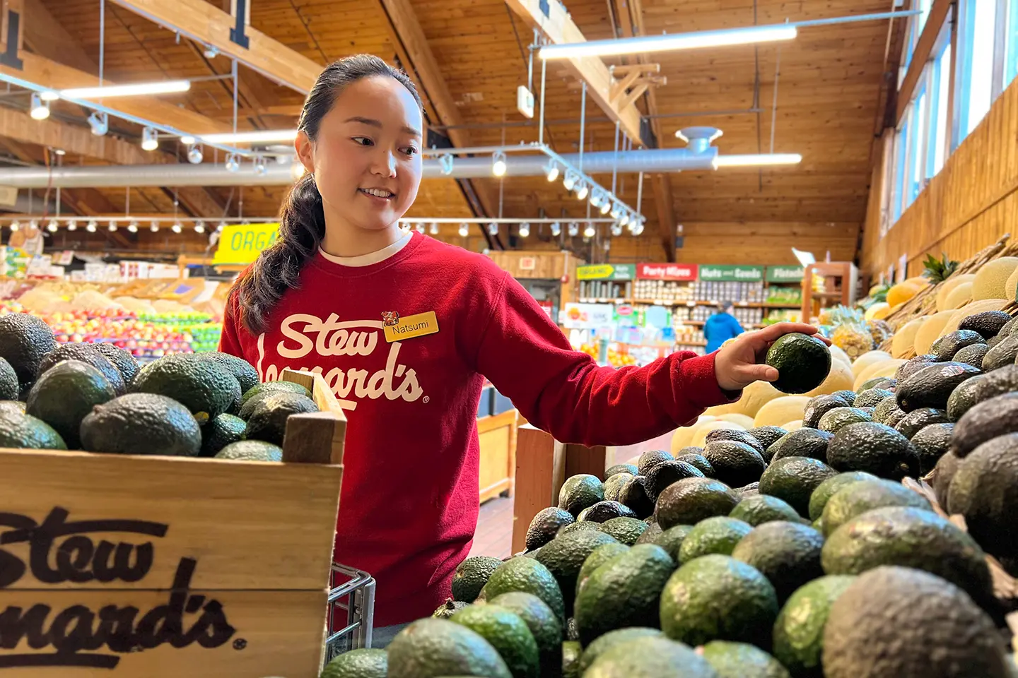 Stew's Team Member stocking an avocado display.